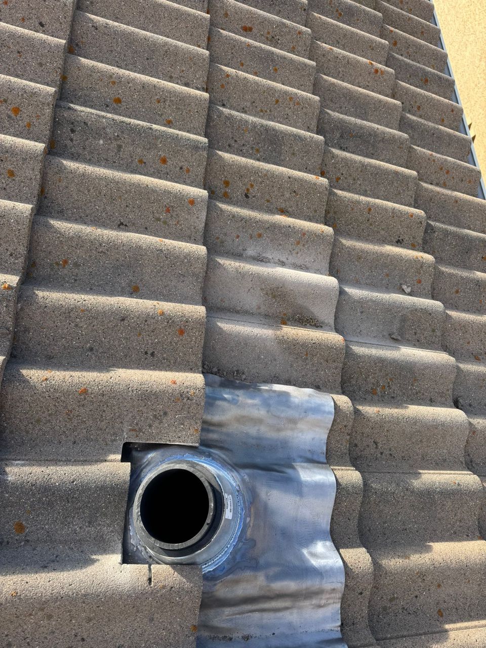 Concrete tile cut to fit around new vent flashing