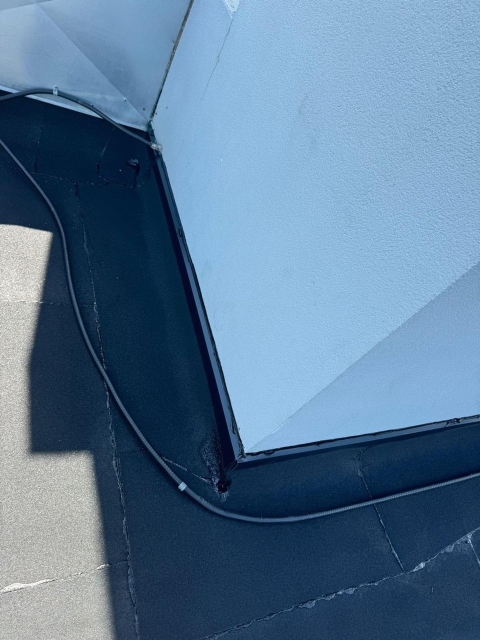 Cracked flat roof membrane at the inside corner of a stucco column