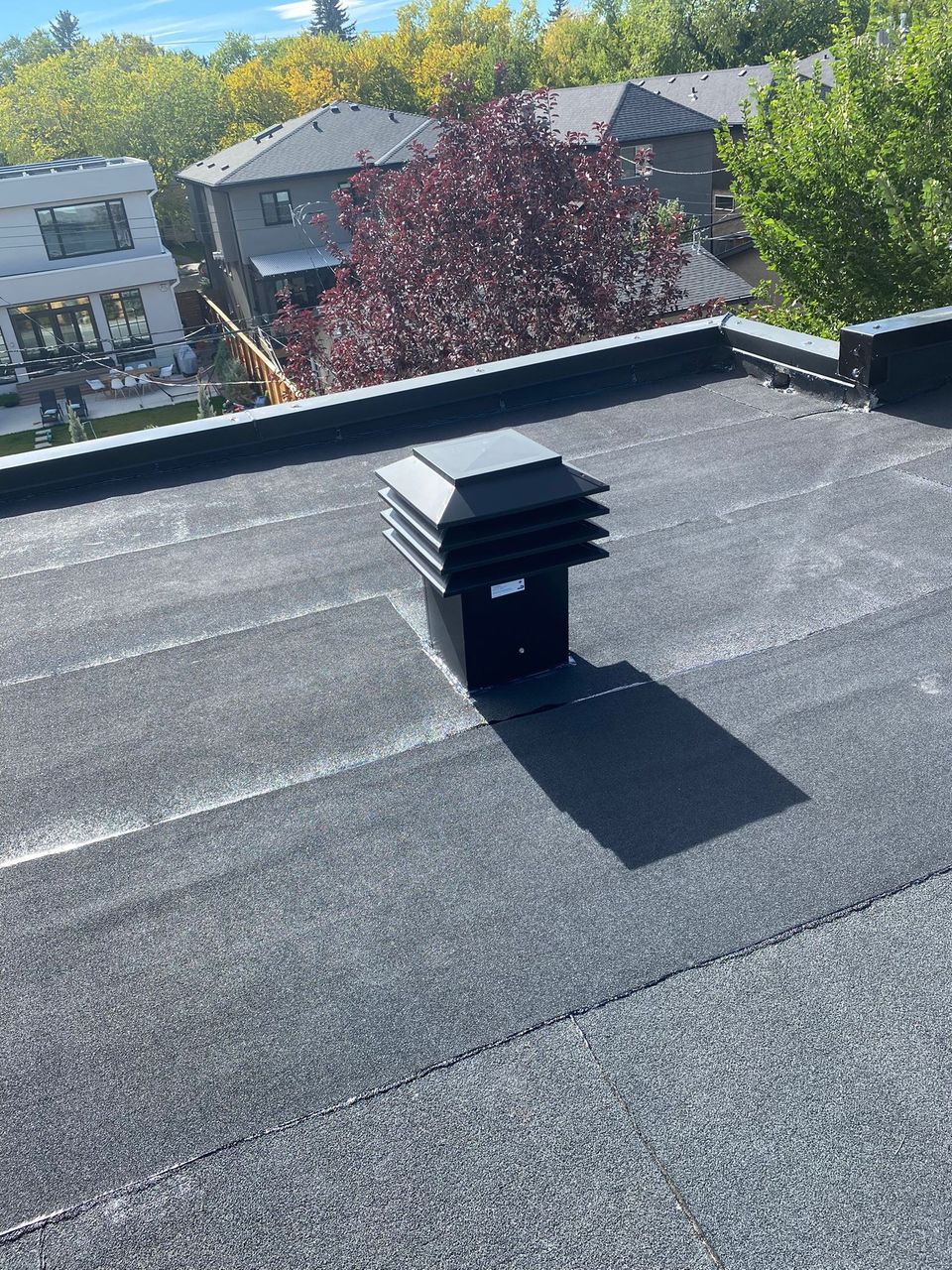 Finished SBS flat roof with a roof vent and parapet metal cap