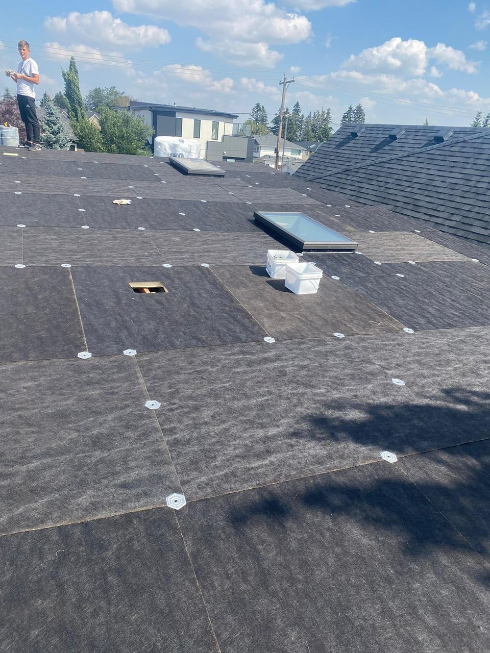 Coverboard fastened with plates around skylights during a Calgary flat roof replacement