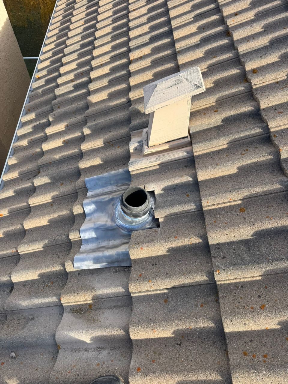 New lead flashing installed around a plumbing vent on a concrete tile roof
