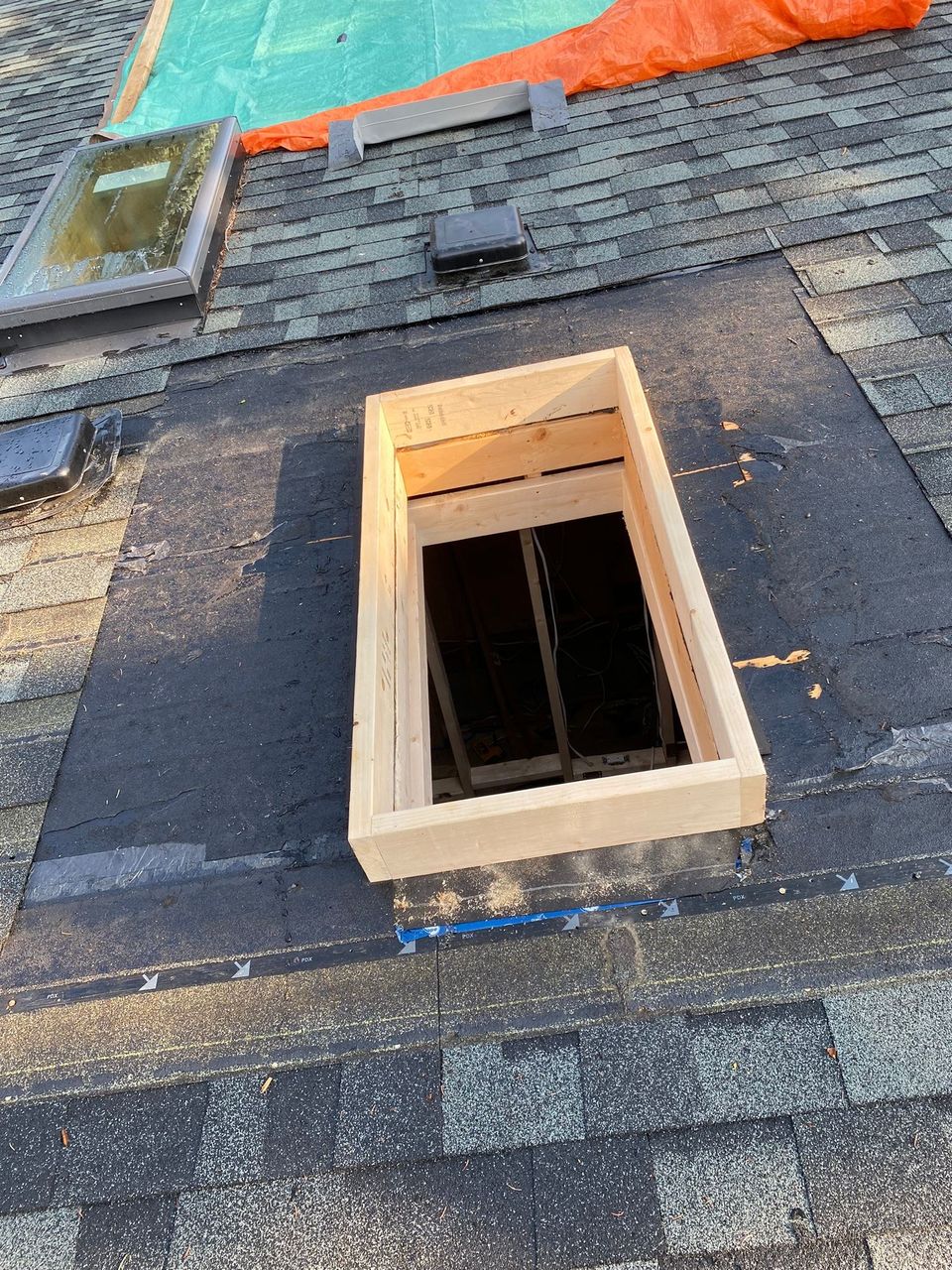 New skylight curb with membrane around it on a shingle roof