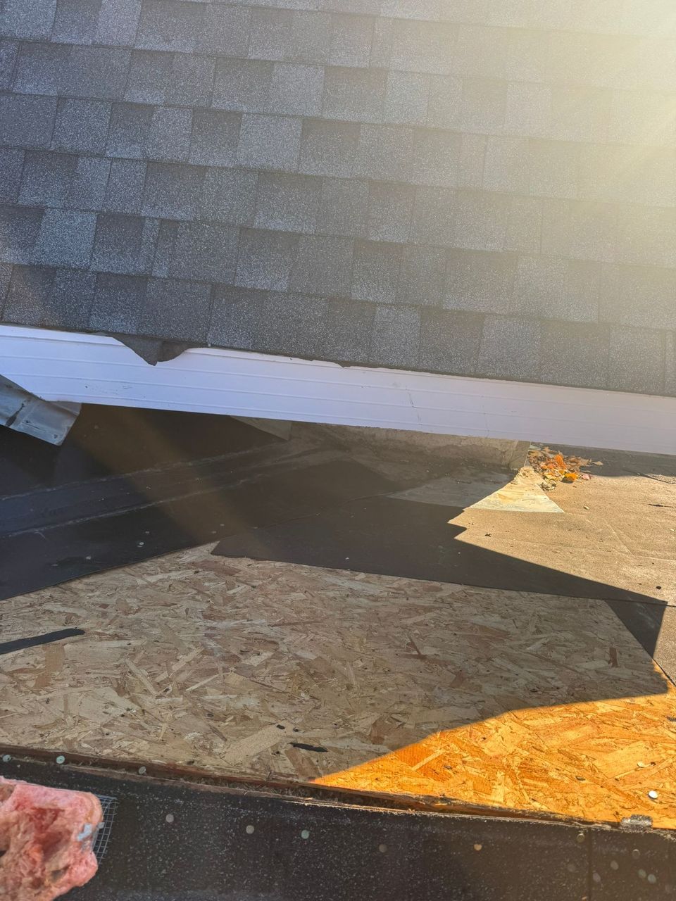 Roof sheathing replaced on a low-slope roof below a shingle wall
