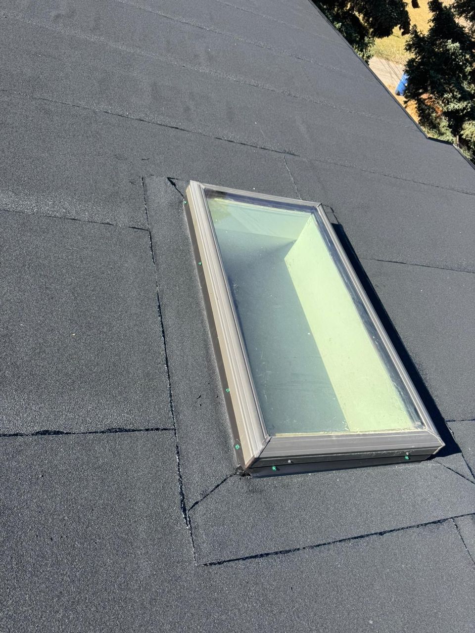 Skylight curb wrapped in granulated SBS cap sheet on a flat roof